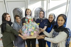 Penny Watson and Miriam Gilbert from SaTH's palliative and end of life care team with ladies from the knitting group and Gillian Denning