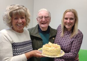 Hannah Morris and Julia Clarke present Terry with a birthday cake