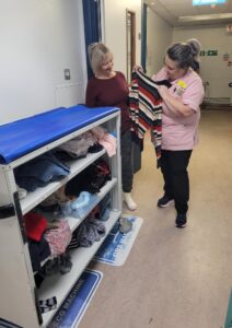 Housekeeper Rachael House shows a patient on Ward 28 some of the clothing